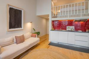 a living room with a couch and a kitchen at Almada 151 - 2F in Porto