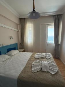 a bedroom with a large bed with towels on it at Er-Öz Hotel in Fethiye