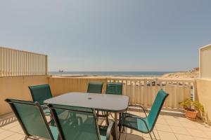 Una mesa y sillas en un balcón con la playa. en Vue imprenable sur l'océan, en Vieux-Boucau-les-Bains