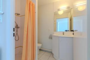 Un baño con lavabo, inodoro y espejo. en Vue imprenable sur l'océan, en Vieux-Boucau-les-Bains
