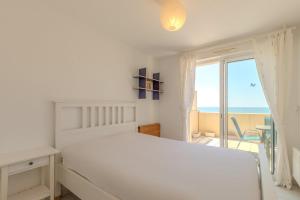 Dormitorio blanco con cama y vistas al océano en Vue imprenable sur l'océan, en Vieux-Boucau-les-Bains