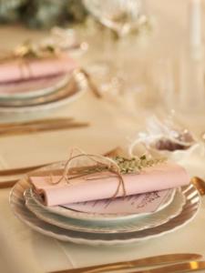 a table topped with plates with pink napkins on them at Stadtwohnung am Oertelplatz in Munich +14 photos