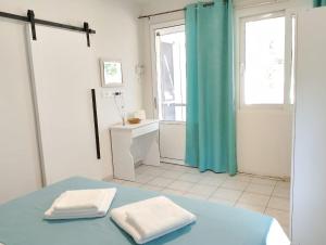a bathroom with a blue shower curtain and two towels at Old Cafe Apartment in Skala Kallirachis +25 photos