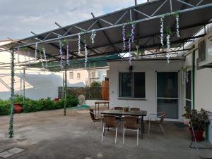 a patio with a table and chairs under a pergola at Old Cafe Apartment in Skala Kallirachis