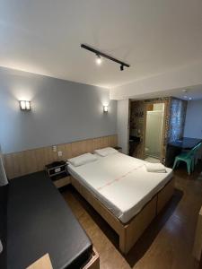a bedroom with a large bed and a table at Calandre Hotel in São Paulo
