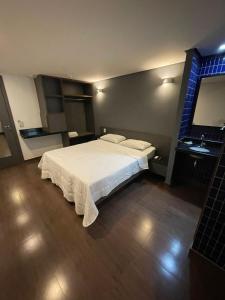 a bedroom with a white bed and a sink at Calandre Hotel in São Paulo