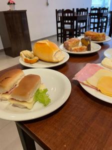 a wooden table with plates of sandwiches on them at Calandre Hotel in São Paulo