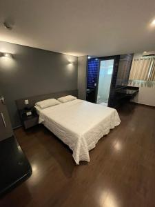 a bedroom with a bed with a white comforter at Calandre Hotel in São Paulo +69 photos