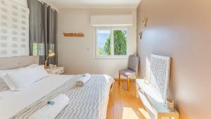 Un dormitorio con una cama, una silla y una ventana en villa frontlake, en Tresserves