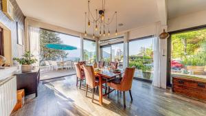 Un comedor con mesa y sillas y una gran ventana. en villa frontlake, en Tresserves