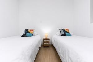 two beds sitting next to each other in a room at Home2Book Sunny Rooftop Duplex, Puerto del Rosario in Puerto del Rosario