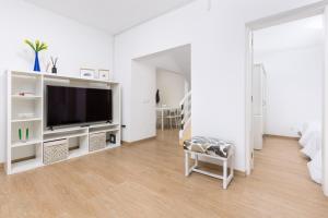 a white living room with a flat screen tv at Home2Book Sunny Rooftop Duplex, Puerto del Rosario in Puerto del Rosario