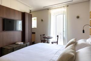 a bedroom with a bed and a tv and a table at Palazzina Gentile in Bari