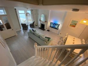 a living room with a couch and a fireplace at Cornwall Large Beach House Sea & Beach Views - 4 Bedrooms & 3 Bathrooms in Looe