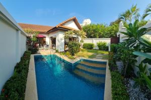 a swimming pool in front of a house at View Talay Holiday Resort in Jomtien Beach