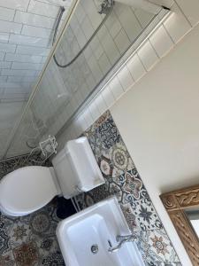 a bathroom with a toilet and a sink at Cornwall Large Beach House Sea & Beach Views - 4 Bedrooms & 3 Bathrooms in Looe