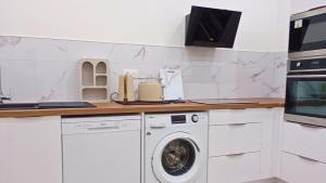 a kitchen with a washing machine and a counter at La Parenthèse Verte - Garden - Air conditioning - Near center in Romilly-sur-Seine +11 photos