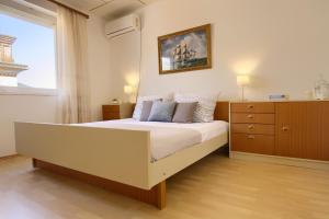 a bedroom with a bed and a dresser and a window at Olea House in Lukoran