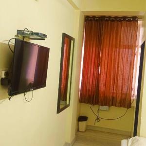Un televisor de pantalla plana en la pared de una habitación. en Hotel Gem, en Jaipur