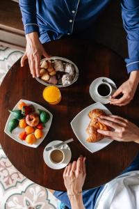 Una mesa con dos platos de comida y dos personas. en Palazzina Gentile, en Bari