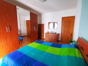 a bedroom with a blue and green bed and wooden cabinets at Your retreat in Mestre - Venezia comoda a due passi in Venice
