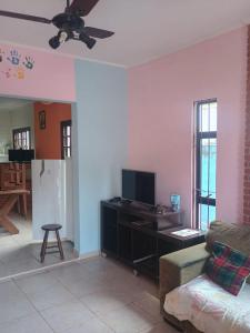 a living room with a television and a couch at Ambiente Familiar in Ubatuba