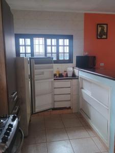 a kitchen with an open refrigerator in a room at Ambiente Familiar in Ubatuba