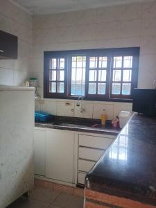 a kitchen with a sink and a window in it at Ambiente Familiar in Ubatuba +9 photos