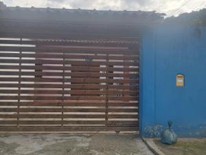 a blue building with a large wooden garage door at Ambiente Familiar in Ubatuba