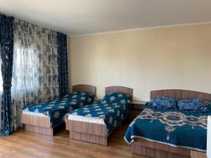 Un dormitorio con dos camas y una ventana en Edelweiss 1, en Cholpon-Ata