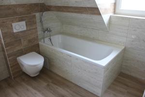 a bathroom with a white tub and a toilet at Roubenka Lučany in Lučany nad Nisou +31 photos