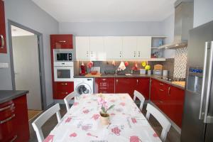 una cocina con armarios rojos y una mesa con flores. en Au Pont De Tuarelli, Ludique, Fango, en Manso 22 fotos más