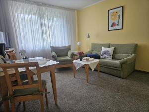 a living room with a couch and a table at Villa Viktoria Whg 5 - "Moosmuschel" in Kolpinsee