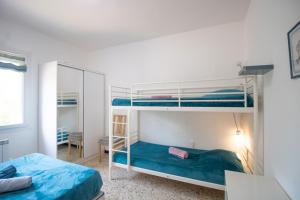 Un dormitorio con dos literas y un espejo. en Au Pont De Tuarelli, Ludique, Fango, en Manso