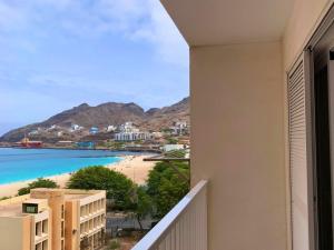 a balcony with a view of the beach and buildings at Mar & Morna in Mindelo