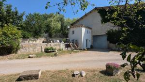a large white building with a garage next to a road at La Petite Grange in Aspres-sur-Buëch