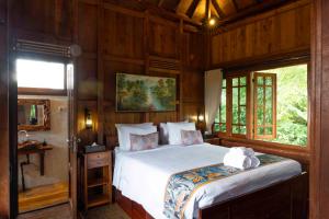 um quarto com uma cama em um quarto de madeira em Manigelang Villa em Munduk