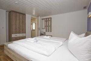 a white bed with two towels on top of it at Ferienhus Baabe - Ferienhaus mit Terrasse, gratis Nutzung vom AHOI Erlebnisbad und Sauna in Sellin in Baabe +25 photos