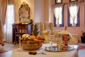 a table with a basket of fruit and wine glasses at Guesthouse Iris in Tsagarada