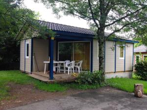 a tiny house with a table and chairs on a deck at Camping Les Craouès in Capvern +6 photos