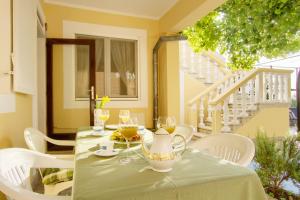 a table with wine glasses and a vase on it at Olea House in Lukoran