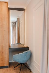 una silla azul sentada frente a un espejo en Cometei Residence Apartments 2, en Cluj-Napoca