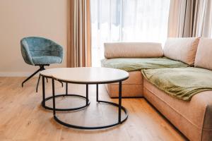 Una sala de estar con un sofá, una mesa y una silla. en Cometei Residence Apartments 2, en Cluj-Napoca