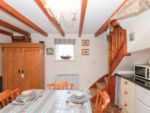 a kitchen and dining room with a table and chairs at The Old Cottage in Staithes +13 photos