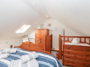 a bedroom with a wooden bed and a dresser at The Old Cottage in Staithes