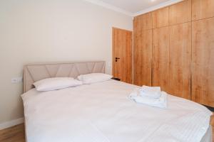 Un dormitorio con una cama con dos toallas blancas encima. en Cometei Residence Apartments 2, en Cluj-Napoca