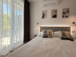a bedroom with a large bed and a large window at Zen apartmanház Gyula in Gyula
