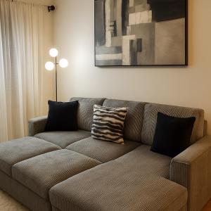a brown couch in a living room with a painting at 10 Min to NYC Quiet 1BR Flash Deal June 22 to 25 in Weehawken