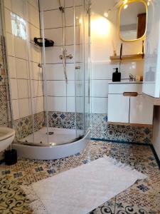 a bathroom with a shower and a white rug at Miętowy domek 