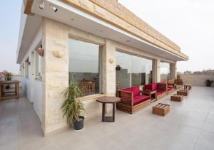 Un balcón con sillas y mesas rojas en un edificio. en Eco green pyramids hotel, en El Cairo